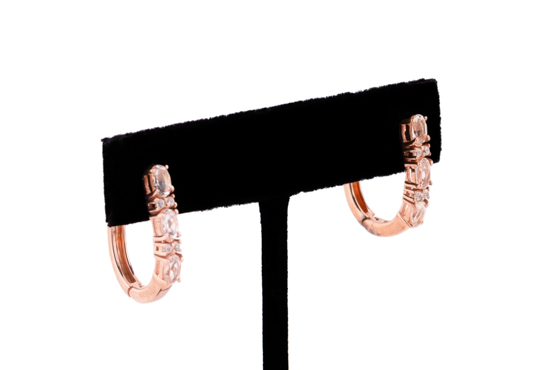 Pair of Rose Gold Plate, Morganite and Topaz Hoop Earrings: Each hoop earring of rose gold plated sterling silver featuring three oval faceted morganite accented by four petite round cut colorless topaz. Stamped '925' and 'INDIA'. Approximate dimensions: