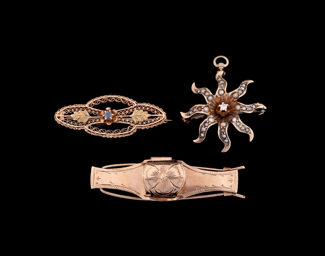Three Victorian 10K Gold Jewelry Items: Including one rose gold floral engraved clip, one yellow gold filigree brooch with two textured leaves and a petite round cut sapphire to center, and one starburst pin set throughout with seed pearls