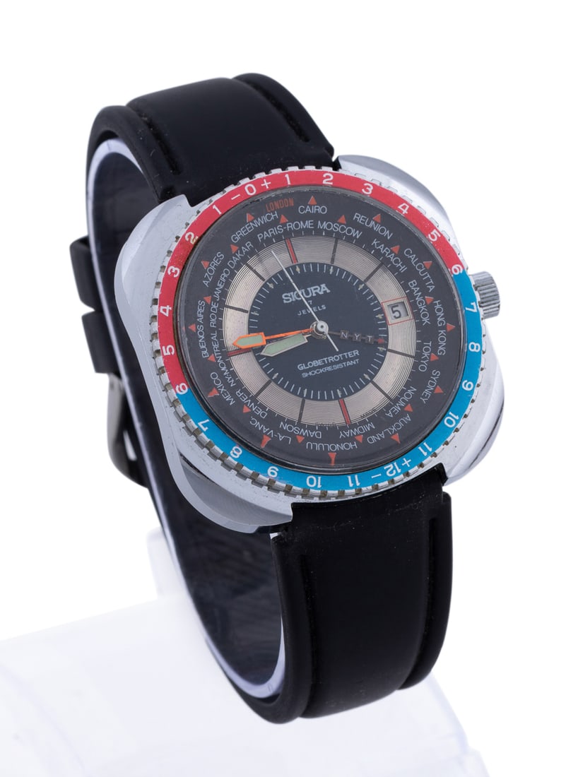 Sicura, Globetrotter GMT Blue & Red Watch, 1970s: Having a black strap band, stainless steel case, mechanical wind movement, blue and silver dial with stick markers, luminous hands, one hand marked NYT, black outer ring marked with 28 world cities, a