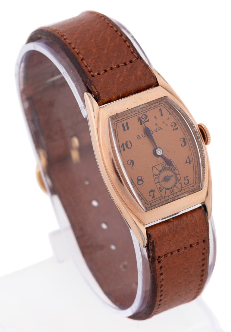 Bulova, Art Deco Men's 10k Gold Filled Wrist Watch: 1940s with a tan leather strap having a gold tone buckle, manual wind movement, tonneau form case with thick crystal, and copper dial having black hour markers and a seconds subdial. Maker's mark to d