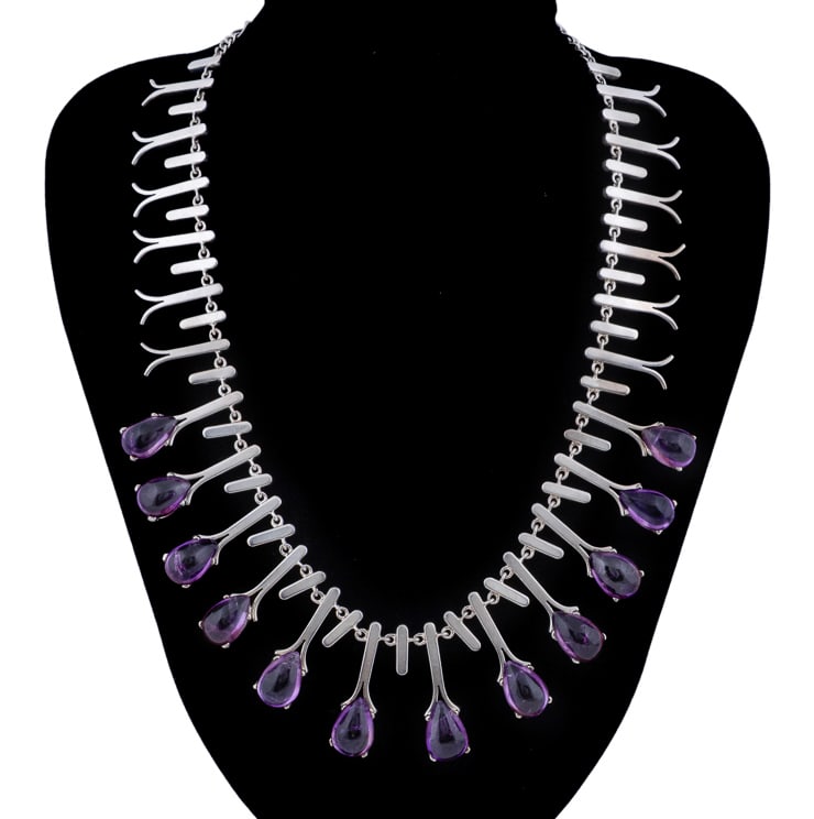 Sterling Silver and Amethyst Fringe Necklace: Composed of articulated geometric silver drops, twelve of the central drops suspending a graduated series of pear shaped cabochon amethysts ranging from approximately 7.36 to 8.67 carats. Stamped '925