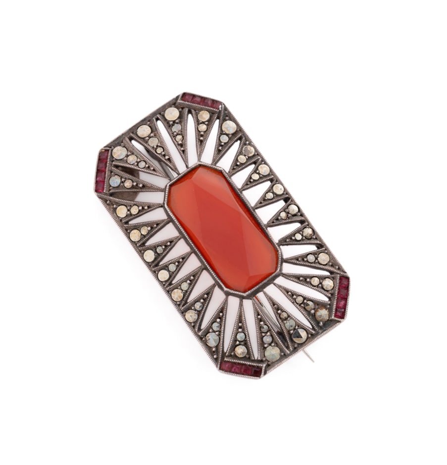 Sterling Silver and Carnelian Brooch: Elongated octagonal form, centering on a faceted carnelian within geometric openwork surround accented by marcasites, with clipped corners each accented by four caliber cut red glass stones. Stamped '
