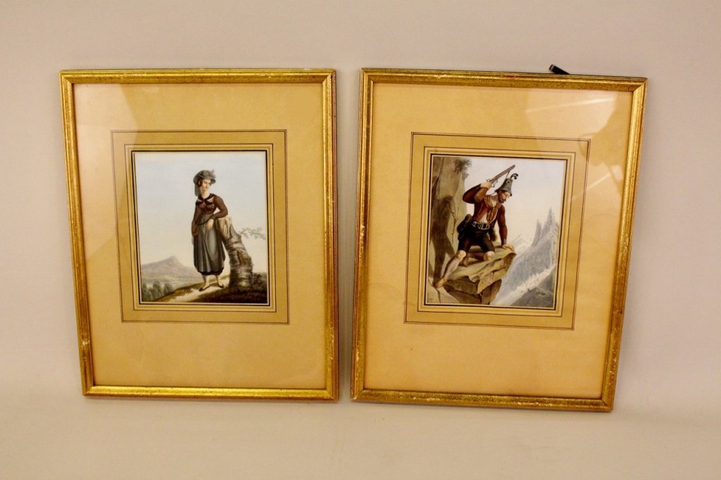 A Pair of 19th C. Handpainted Engravings.: Framed, finely hand painted and depicting figures at full-length. One of a barefoot Tyrolean man kneeling on a cliff side holding a rifle as he gazes down at a small herd of mountain goats; the other