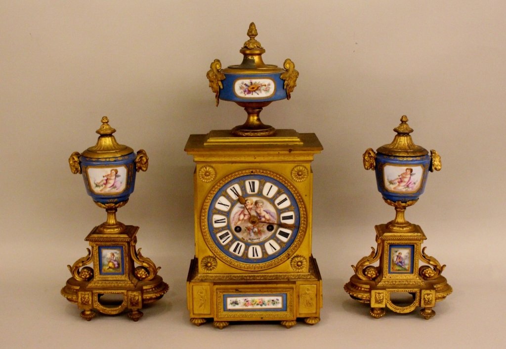 Sevres Style Clock and Garniture.: Clock face with two winged putti figures above a knight's hemet. Numbers in Roman numerals. Clock face marked "BENNETT 65 & 64 Chearside London". Back of clock with "PH MOREY". Porcelain medallions wi