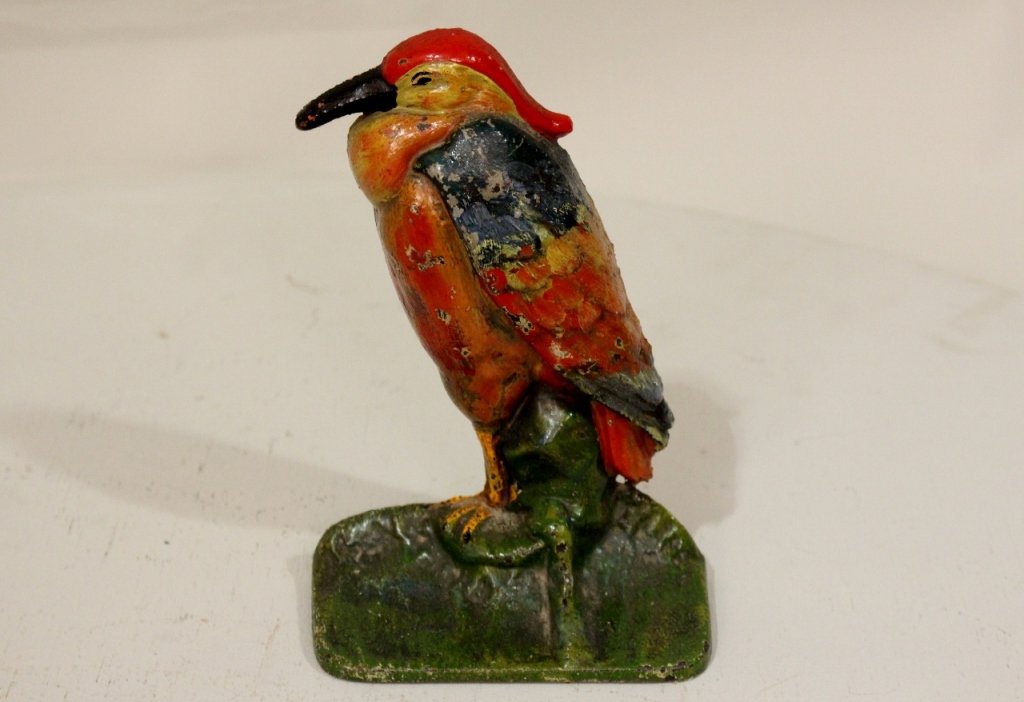 A Painted Cast Iron Doorstop: In the form of a brightly colored bird.