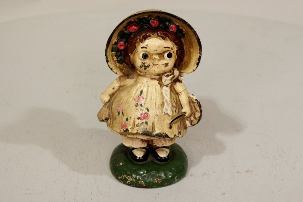 A Painted Cast Iron Doorstop: In the form of "Dolly Dimple."
