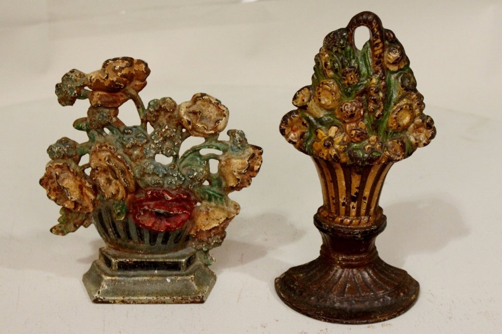 A Group of Two Painted Cast Iron Doorstops: In the form of baskets full of flowers.