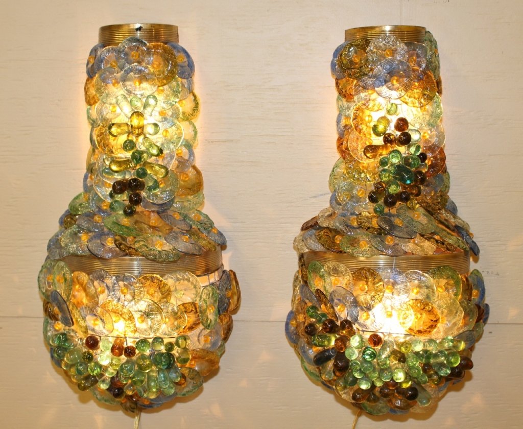 Pair of Art Glass Sconces, 20th C.: Two matching multicolored art glass wall sconces with each with two lights within a brass vase form mount. Electrified wall sconces with disk and finger form art glass decoration in overlapping cluste