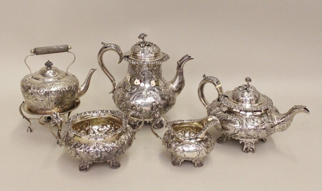 4 Piece English Sterling Silver Cofee/ Tea Set: Together with an additional unmatched floral decorated wood handled teapot on footed candle burner stand. Wood handled teapot marked inside lid. Four piece set includes a footed and handled tea pot, c