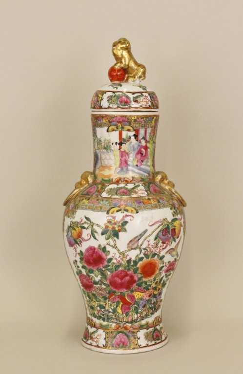 Chinese Famille Rose Lidded Urn: Chinese famille rose covered urn decorated with pink peonies, butterflies and figures at top with a gilt foo dog finial. Marked on bottom. Height 22 inches.