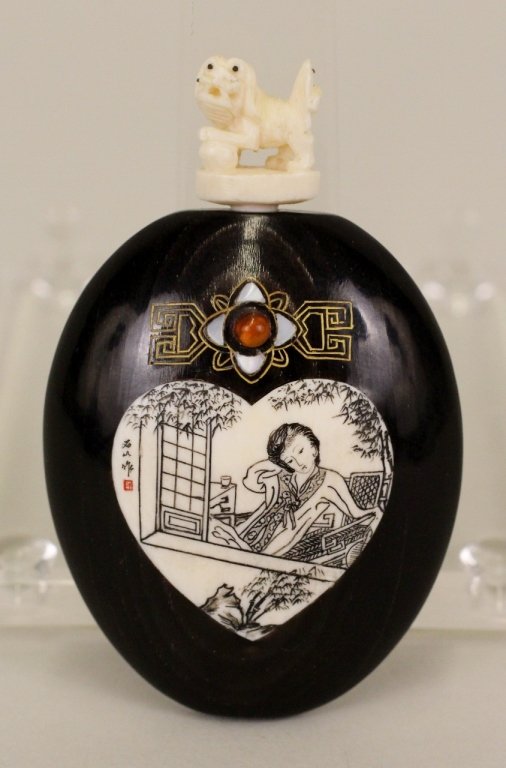 Ebonized Wood & Bone Inalid Snuff Bottle: Oriental ebonized ovoid form bottle with bone inlaid in heart form with figural engraving (with characters on left) below a mother of pearl inlaid flower. Stopper composed of carved bone with foo dog 