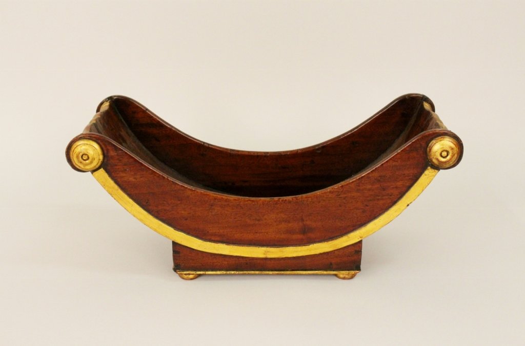 Regency Mahogany Sleigh Planter/Display Bowl: 19th century. Wooden sleigh form cheese wheel holder or display planter with gilt wood banding, handles, and medallions at top. Raised on four squat gilt feet. Height 7.6 inches, width 17.6 inches, de