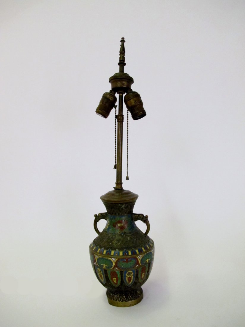 Champleve Table Lamp: Bronze and champleve table lamp in urn form with two animal's head handles with open mouths and elongated stylized tongues. Floral, tree, and shield form champleve work in banding on geometric pattern