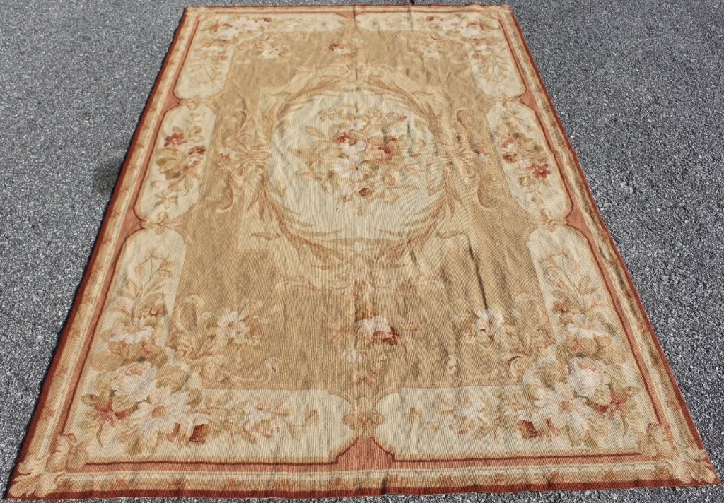 Aubusson Needlepoint Rug: Aubusson hand woven needlepoint rug with floral decoration of roses and daisies in oval medallion at center and with additional floral and leaf decoration stemming from center and extending to rug bor