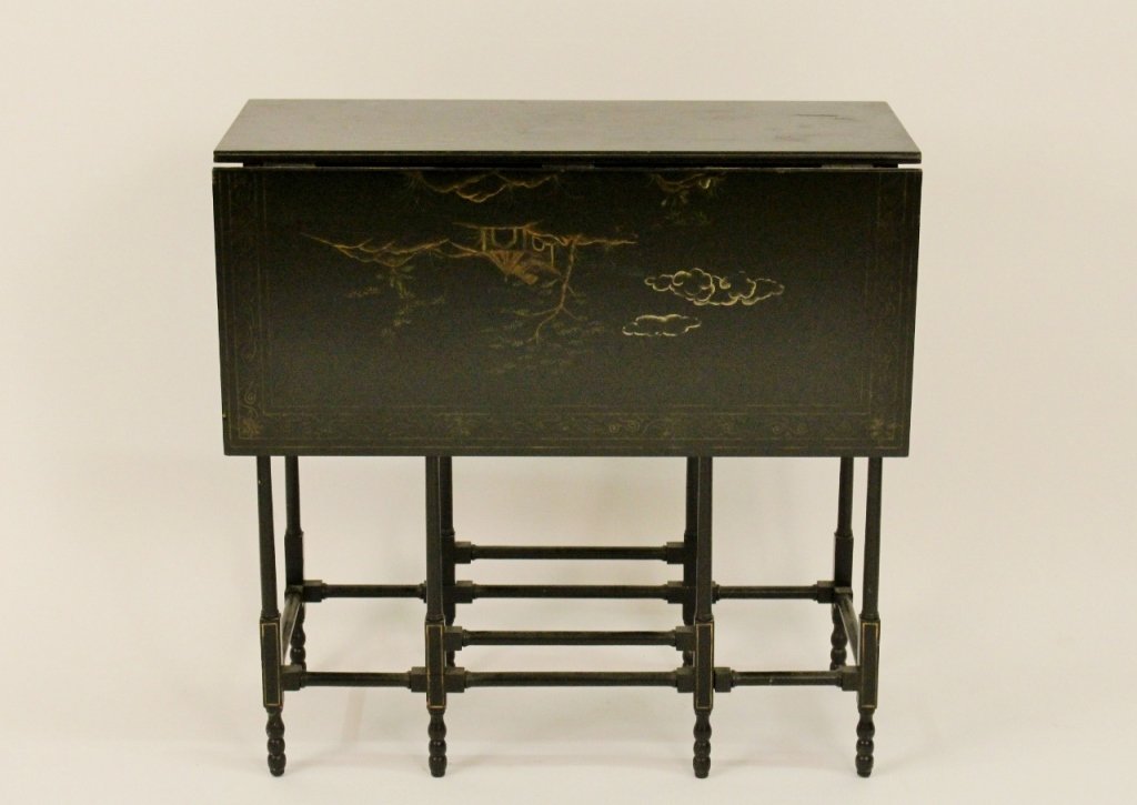 Black Lacquered Chinoiserie Drop Leaf Table: Black lacquered drop leaf table with chinoiserie figural and architectural decoration on rectangular table top and tops of drop leaves. Frame with thin rectangular frame with gilt accents and two gate
