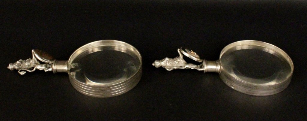 Two Luiz Ferreira Silver Magnifying Glasses: Luiz Ferreira (Portugeuse 1909-1994). Two Ferreira magnifying glasses with silver handles with royal standing lion wearing crown on head and leaning against a stone medallion. One with an oval red blo