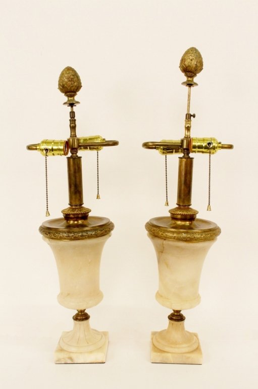 Pair of Alabaster Urn Lamps: Continental School, 19th century. Carved alabaster urns with fluted decoration on round foot and raised on square plinth base. Lamps with matching dore bronze fittings with leaved wreath detail. Later