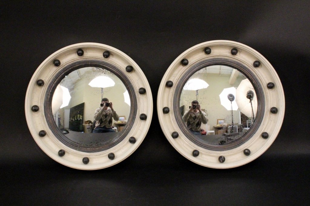 Pair of Painted White & Black Bullseye Mirrors: 20th century. Federal style circular convex bullseye mirrors contained within white painted wood frame with black painted ball banding and reeding and antiqued finish. Overall diameter 18 inches. Diam