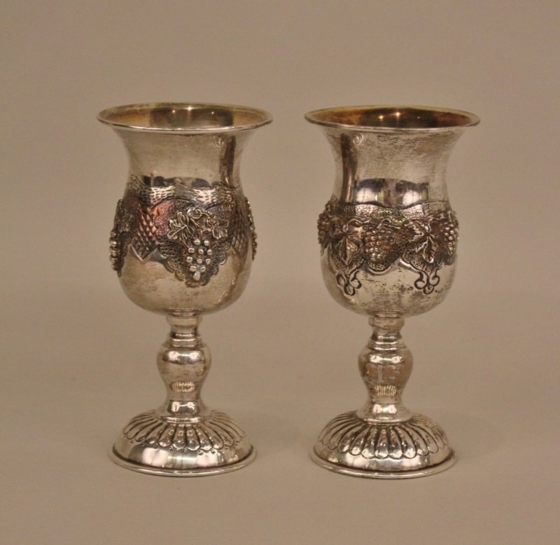 Pair of Sterling Silver Chalice Form Goblets: Kiddish cups with grape and vine decoration. Unmarked. Each marked "925" on outside of bottom rim. Each weighs approximately 6.1 troy ounces.