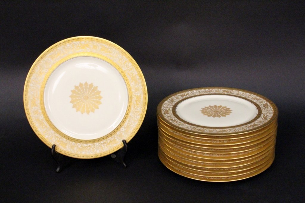 Set of 12 Heinrich & Co Dinner Plates: Bavarian, 20th century. Set of twelve Heinrich & Company porcelain dinner plates with ornate gilt decoration including floral form at center of tondo with gilt banded rim with scrolled foliate decorat