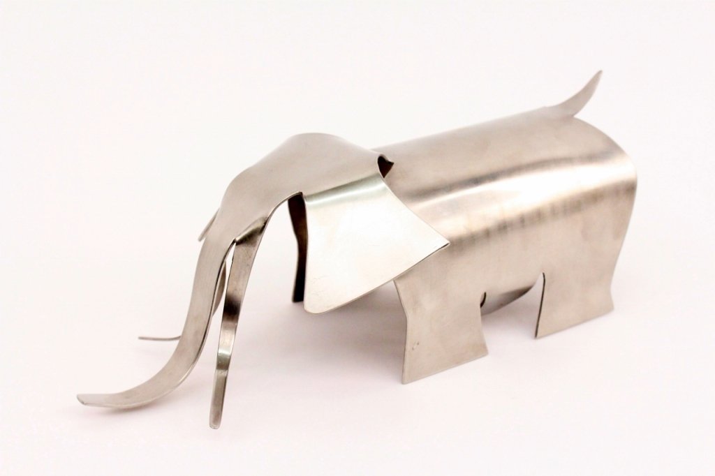 Hagenauer Modern Metal Elephant Sculpture: Hagenauer Werkstätte (Austrian, 20th century). Modern nickel metal sculpture of an elephant depicting the animal on all four legs with stylized and minimal tusks, trunk, ears, legs, and tail. Marked