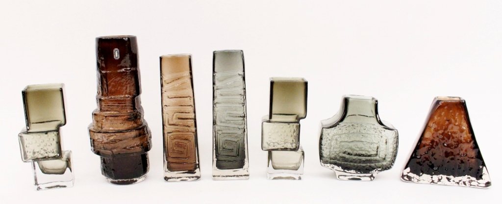 Seven Baxter for Whitefriars Art Glass Vases: Geoffrey Baxter (British 1922-1995)for Whitefriars. Group of seven 20th century British Whitefriars art glass vases in dark grey, brown, and green tinted tones. Vases of varying sizes with varying tex