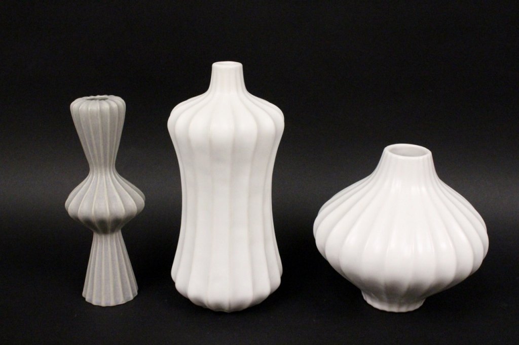 Three Jonathan Adler Designer Vases: Three Jonathan Adler (American, Contemporary) vases. Two in white and one in grey. Each of different form, however, all with ribbed textural motif. All marked on bottom. Height of taller white vase 9.