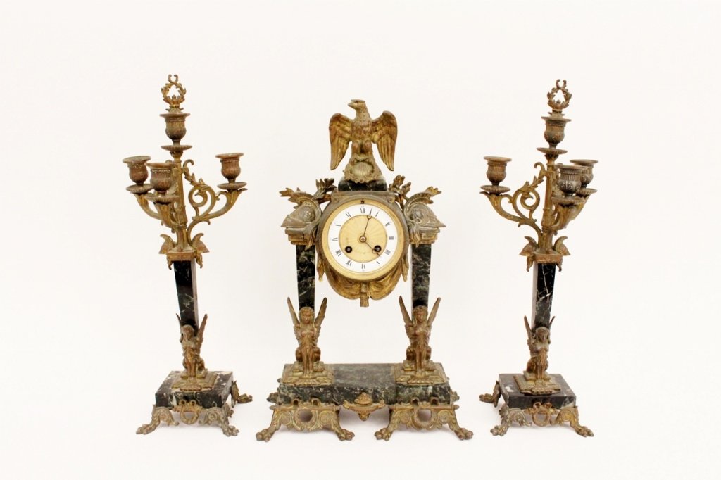 Marble & Bronze Clock & Garniture: French, 19th century. H & H green marble and bronze clock and candelabra garniture set. Clock with circular white porcelain face with banded gilt metal accents above curtained swag bronze mount. Clock