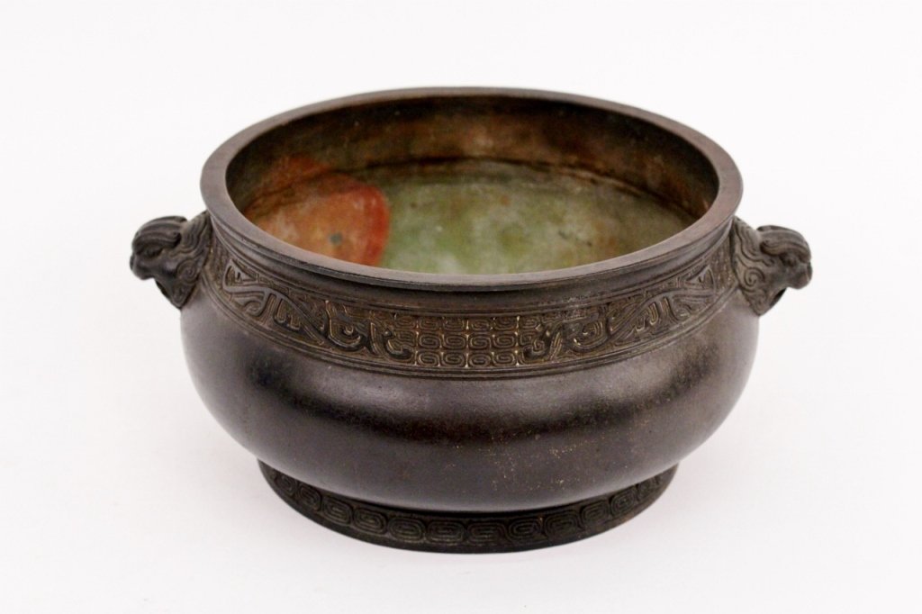 Chinese Bronze Censer: Chinese bronze metal censer of squat pot form. Metal pot with patterned banding in meandering spiral motif and two foo dog face handles. Marked on bottom. Height 3.75", diameter of top 6.5".