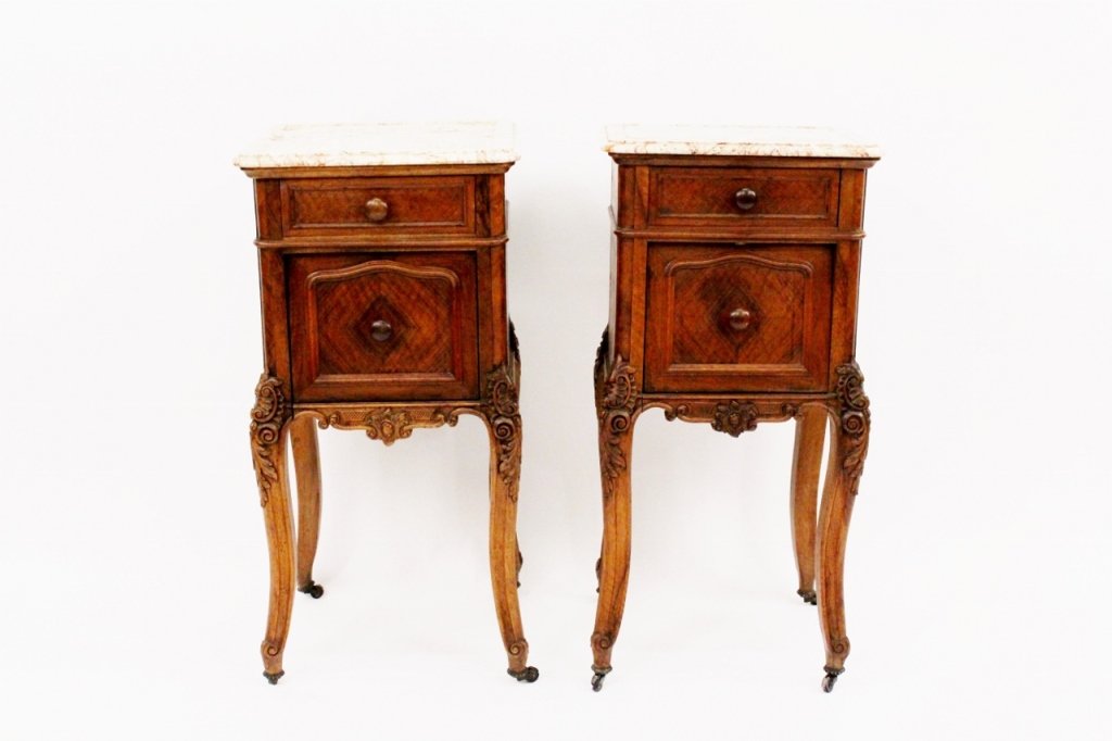 Pair of Louis XV Style Commodes: Continental, Late 19th/Early 20th century. Pair of two matching walnut wood bedside commodes or nightstands with molded marble tops above one pull out drawer over marble lined drop front compartments.