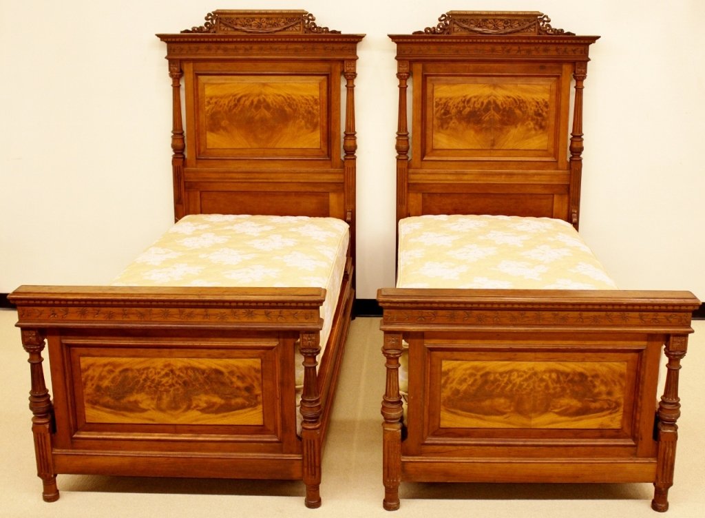 Pair of 19th C. French Walnut Twin Beds: French, 19th century. Pair of matching twin beds constructed of walnut wood. Headboards with carved floral and ribboned decoration at top above additional band with floral detail above paneled back wi