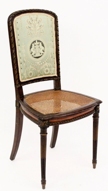 French Vanity Chair with Caned Seat: French, 20th century. Ladies' vanity or side chair with mahogany wood frame with ribbon decorated back surrounding sage green fabric upholstery with Neoclassical motif in pink and gold. Seat with brow