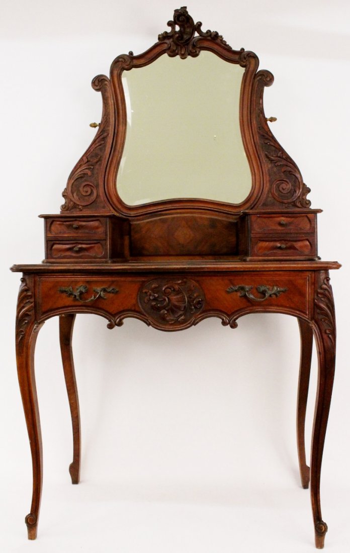 French LXV Style Walnut Dressing Table: French Louis XV style walnut vanity or dressing table with one pull out drawer below top with four smaller pull out drawers. Beveled swiveled mirrored top with scrolled foliate decoration on frame. Lo