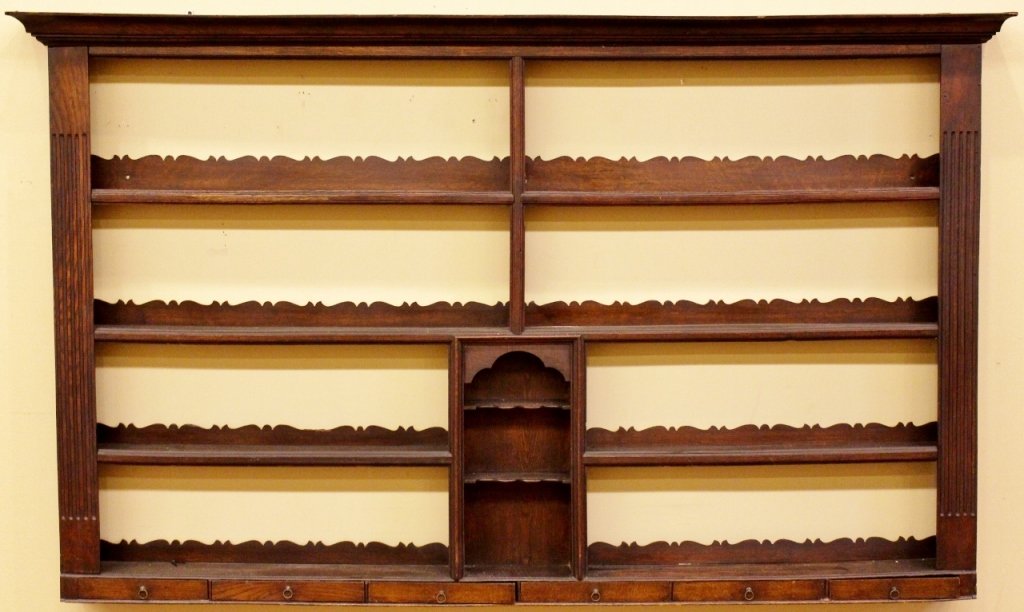 19th C. Welch Oak Hanging Plate Rack: Welch, 19th century. Stained oak hanging china rack with cornice form top above four china or plate shelves with shaped backs flanked by fluted pier form sides above six pull out drawers at bottom. Ce