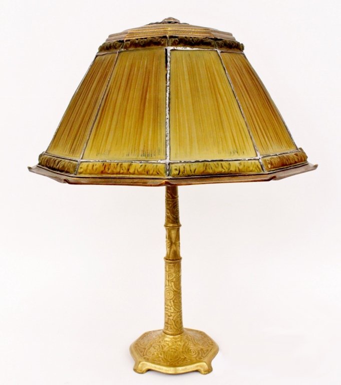 Tiffany Favrile Glass & Gilt Bronze Linenfold Lamp: Tiffany Studios favrilefabrique or linenfold table lamp with green pressed glass tiles in the style of pleated silk lamp shades on decagonal shade above two electrified lap socket raised on a gilt bro