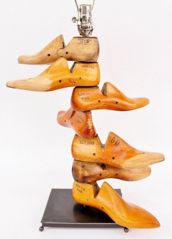 Vintage Shoe Mold Table Lamp: Interesting table lamp composed of seven antique wooden shoe molds that swivel on shaft above a rectangular metal base with round ball feet. Each wooden shoe mold with various markings and signs of we