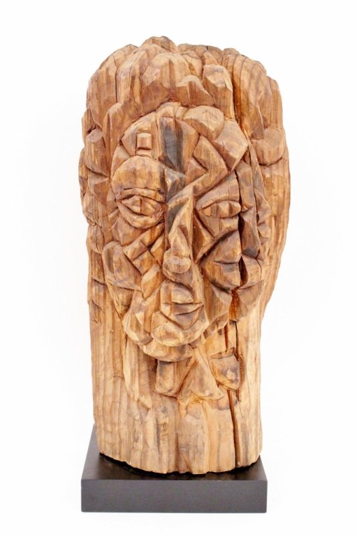 Modern Carved Wood Figural Sculpture: American, 20th century. Modern and abstract style carved wood figural sculpture depicting a face in angled cubist form. Unsigned. Height of wood carving 18.9". Provenance: From the Collection of Walte