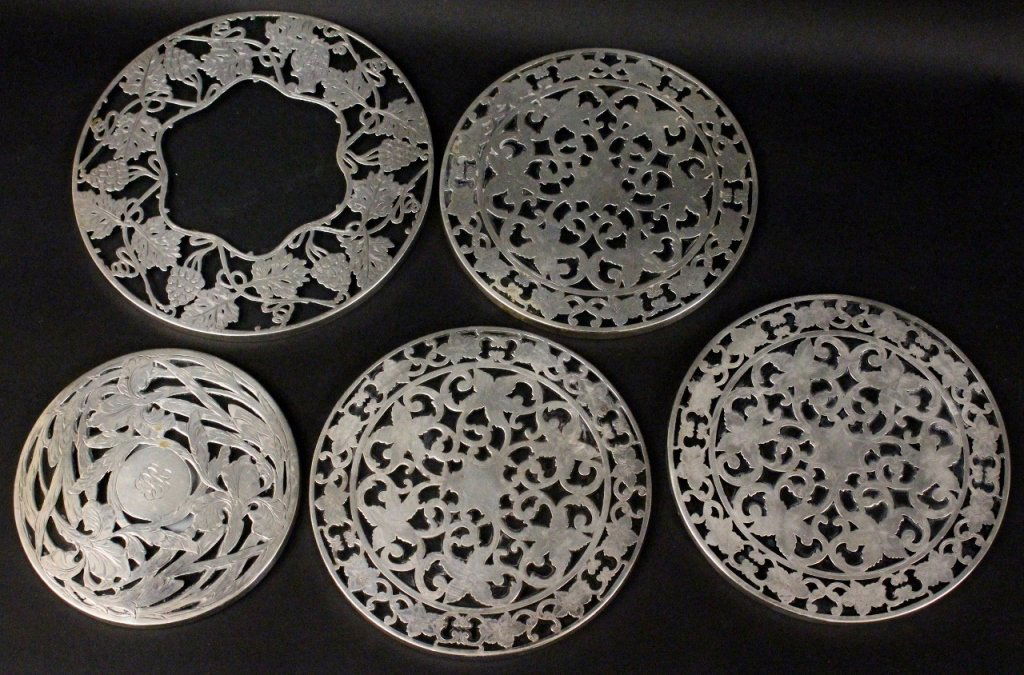 Group of Five Sterling Overlay Glass Trivets: American, 20th century. Group of five Art Nouveau sterling silver overlay circular glass trivets comprising of three matching Webster Company (North Attleboro, MA) trivets with floral and foliate deco