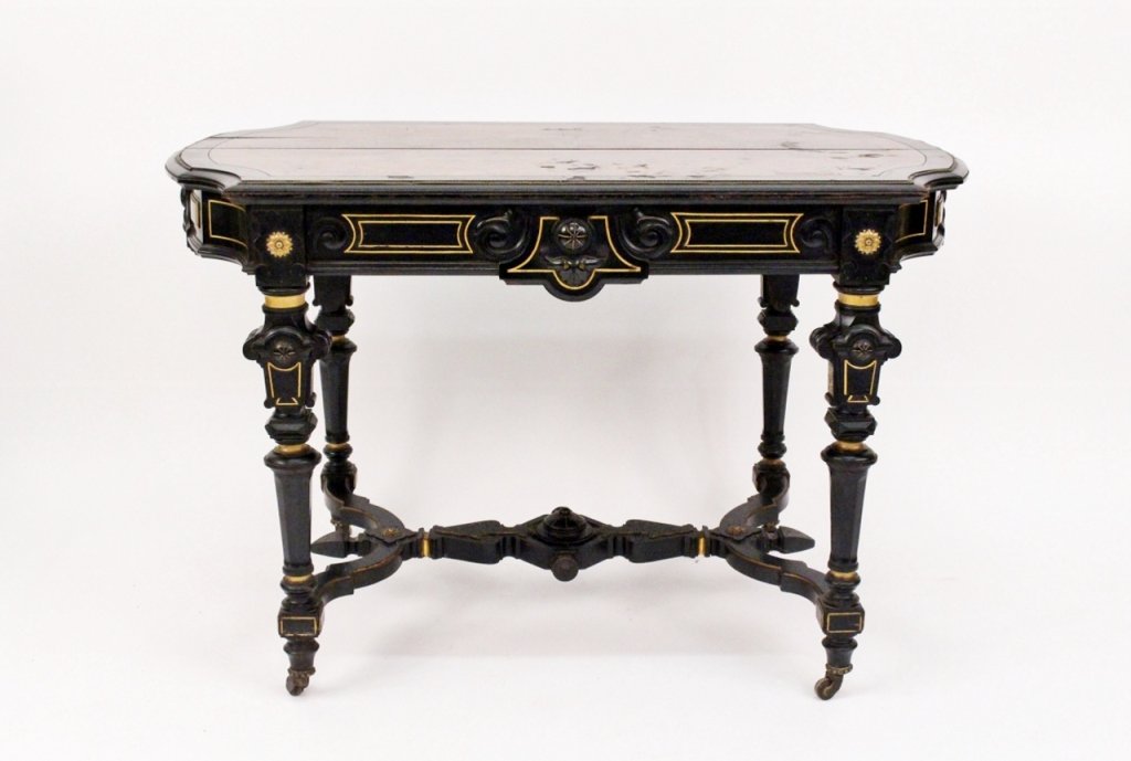 Ebonized & Burled Mahogany Center Table: Late 19th/Early 20th century. Parlor or center table with ebonized and gilt accented wood frame with inset burled mahogany veneered top. Table apron with floral gilt metal mounts, scroll work, circula
