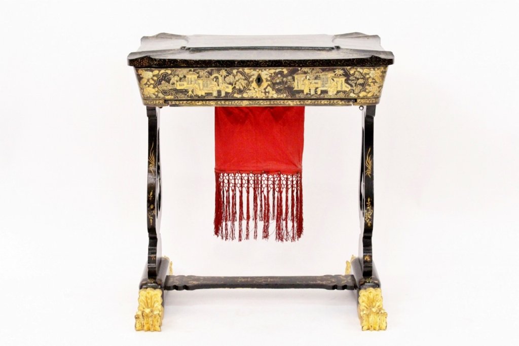 English Chinoiserie Sewing Table: English, 19th century (circa 1880). Black lacquered sewing table with finely painted and gilt accented chinoiserie decoration throughout. Hinged top lifts to reveal compartments, ivory sewing wares, a