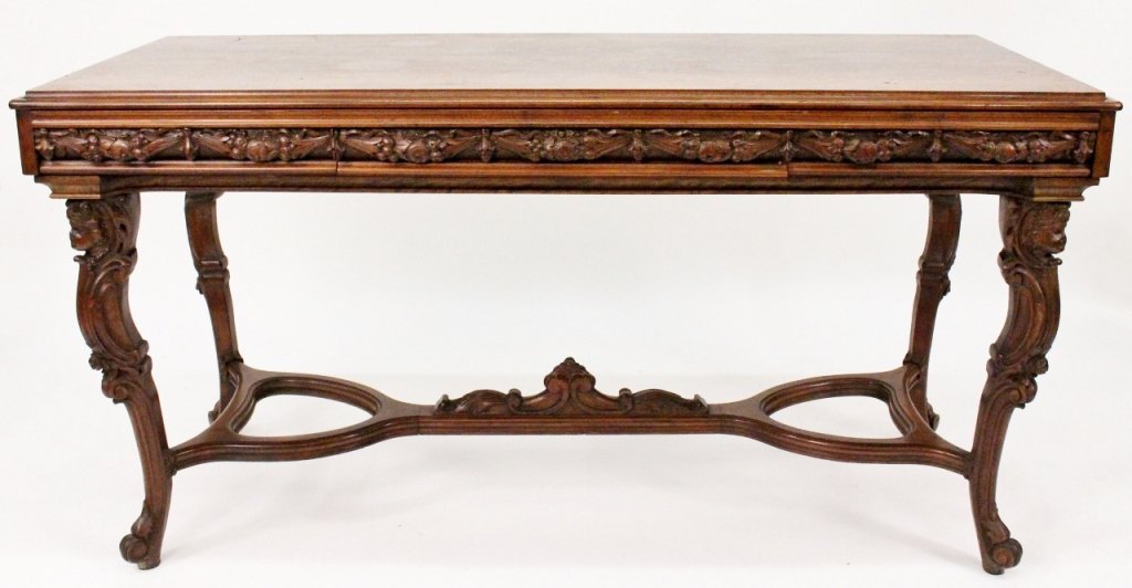 Carved Rosewood Draw Leaf Table: Carved rosewood draw leaf table of rectangular form with ogee edge above apron with fruit and nut ribboned swags above four cabriole legs with Victorian facial mask knees above arabesques terminating