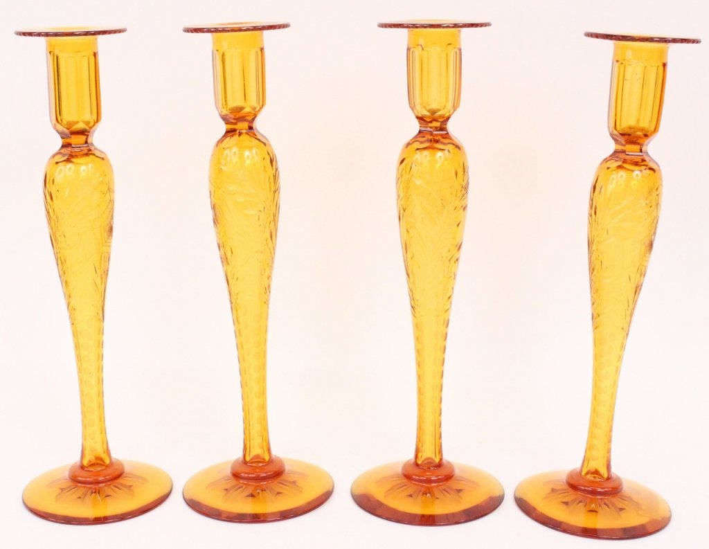 Set of 4 Amber Bohemian Glass Candlesticks: Continental School, second half of 20th century. Set of four matching Bohemian glass candlesticks composed amber colored cut, molded and etched glass with floral, butterfly and spider web motif on tap