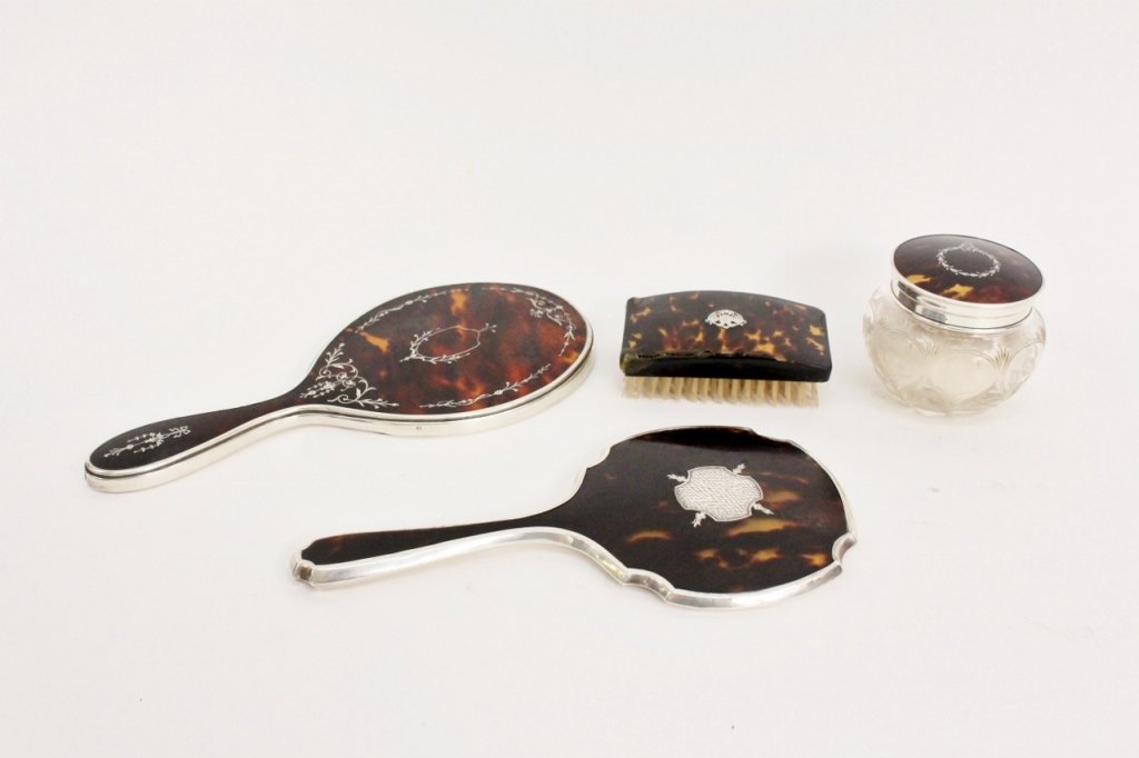 Group of 4 Victorian Tortoiseshell Vanity Pieces: British, First quarter of 20th century. Collection of four Victorian tortoise shell vanity items comprising of two sterling silver mounted hand mirrors, a rectangular hair brush, and a sterling overla
