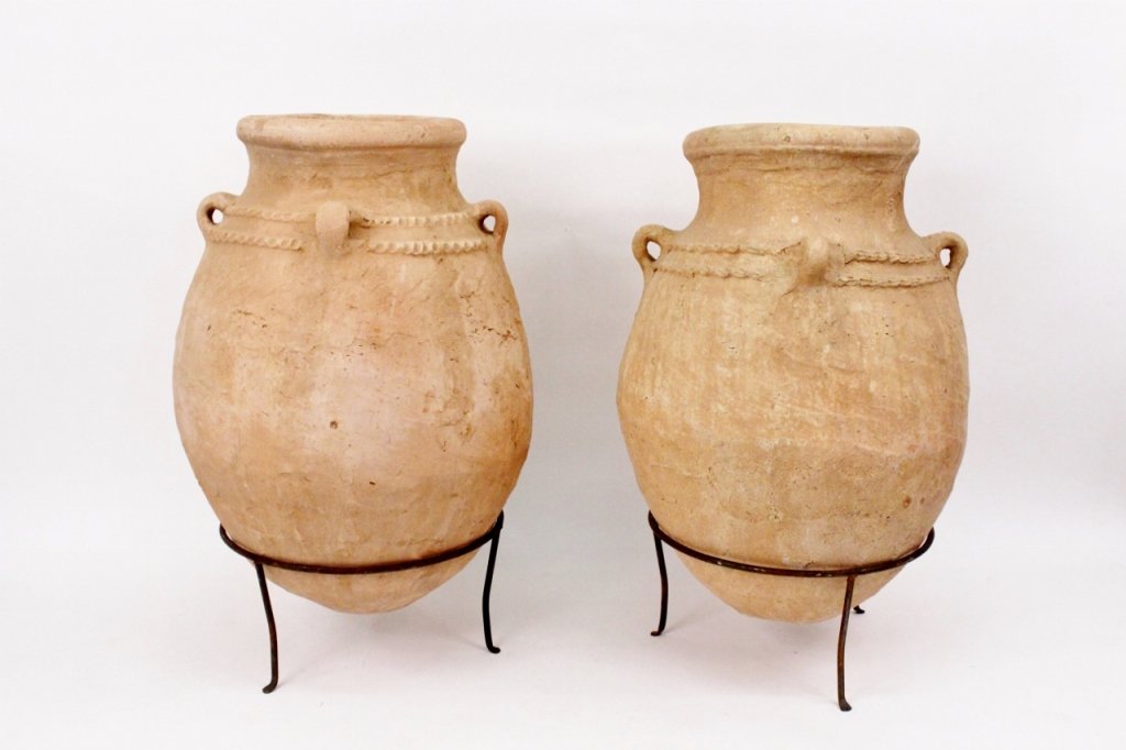 Pair of Continental Terracotta Olive Jars: Pair of matched Continental School terra cotta olive jars. Each with four handles on exterior and double decorative band on fitted wrought iron stands. Height 37.5", diameter of mouth15.25", width (ac