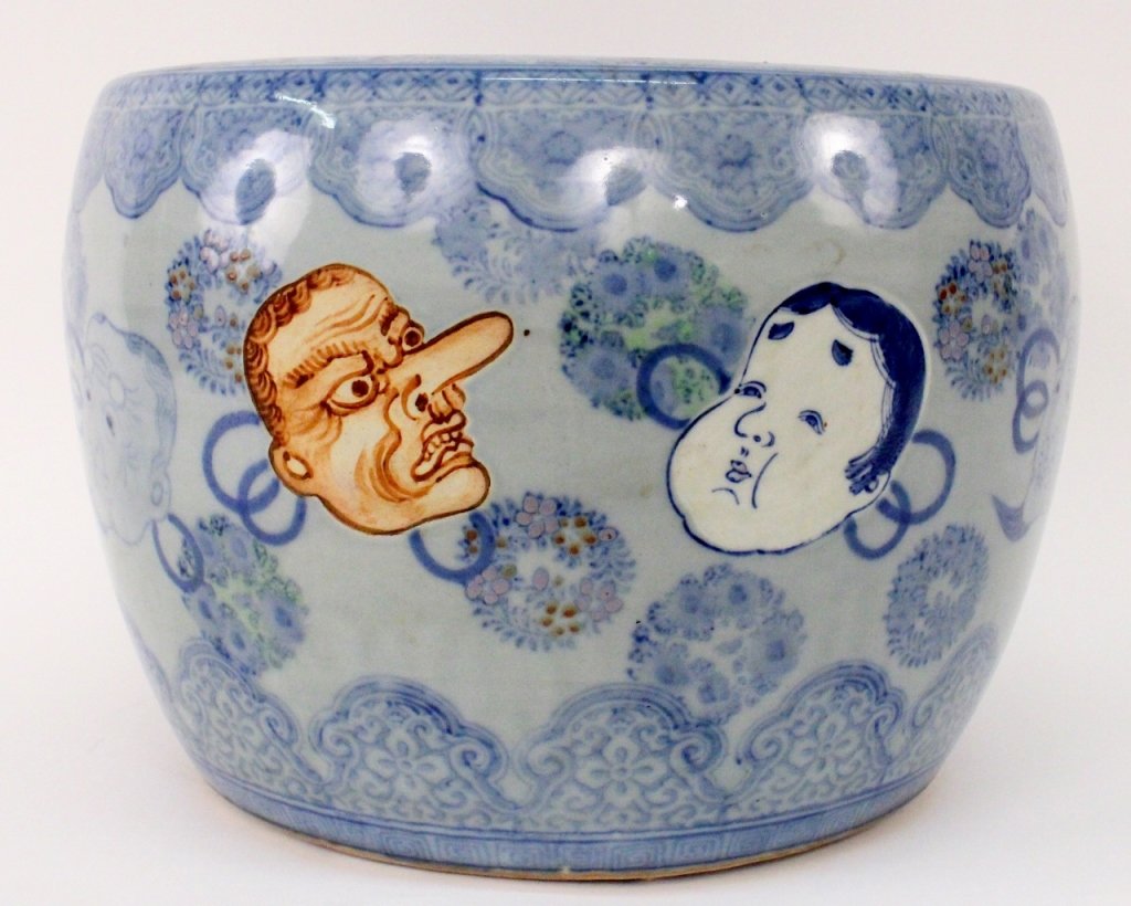 Large Japanese Fish Bowl Planter with Kabuki Motif: Large Japanese porcelain fish bowl or vessel with flow blue circular wreath decoration and banding at top highlighted with colored enamels. Further ornamented with kabuki or noh masks including brown