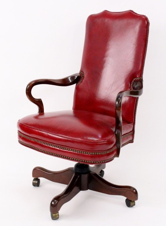 Mahogany Leather Executive Desk Chair: 20th century. Executive desk chair covered in burgundy leather with brass nail head trim raised on mahogany swivel base with casters. Height 44.5", width 11.5" (arm to arm), seat depth 20", seat heigh