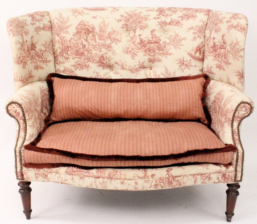 Wingback Settee with Toile Upholstery: Vintage toile wingback upholstered settee with striped seat and pillow cushion, and accent brush fringe. Down-filled. No maker's marks. Seat, 19" to floor. 53" L x 30" W x 46" H