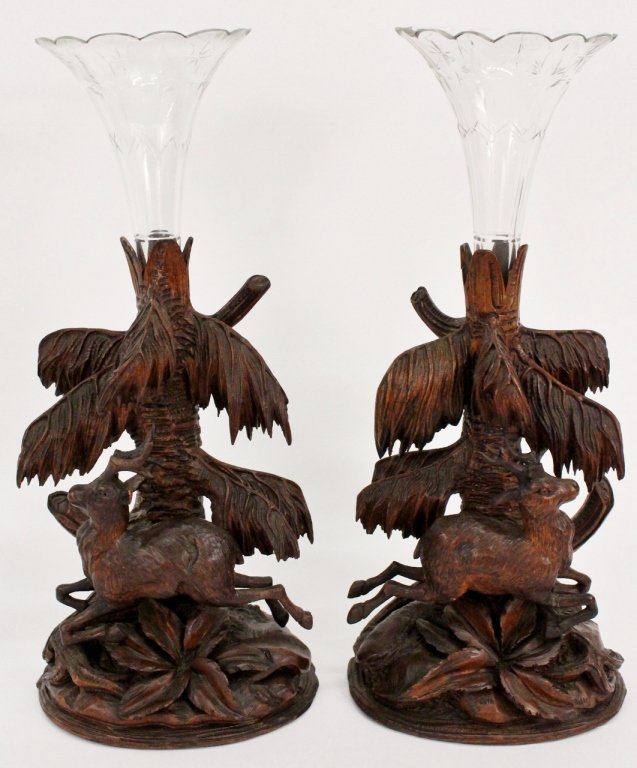 Carved Black Forest Figural Vases: 19th century pair of Black Forest carved wood and glass figural spill or mantle vases, each surmounted with trumpet shaped cut glass within a carved wooden support formed as a tree trunk, a leaping de