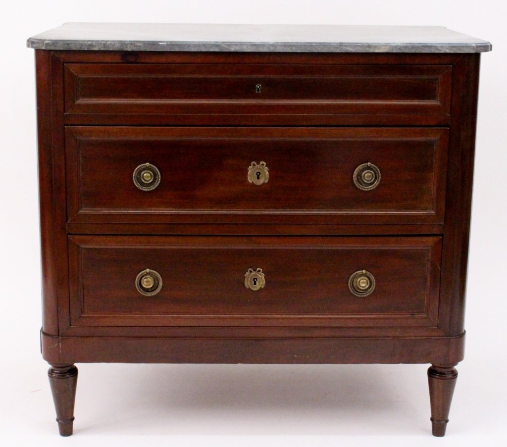 Empire Style Marble Top Three Drawer Commode: Late 19th century. Empire style mahogany commode with grey marble top with ogee edge above three paneled long pull out drawers (lower two with wreathed escutcheons and circular pulls. Three drawer che