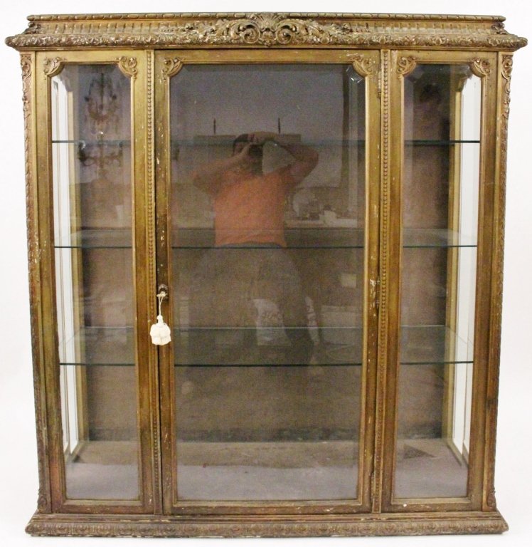 French 19th C. Carved Gilt Wood Vitrine: French, 19th century. Louis XVI style carved gilt wood vitrine or display cabinet with fluted cornice top with ornate acanthus leaf and shell motif at center with leaf tip accented edge above framed b